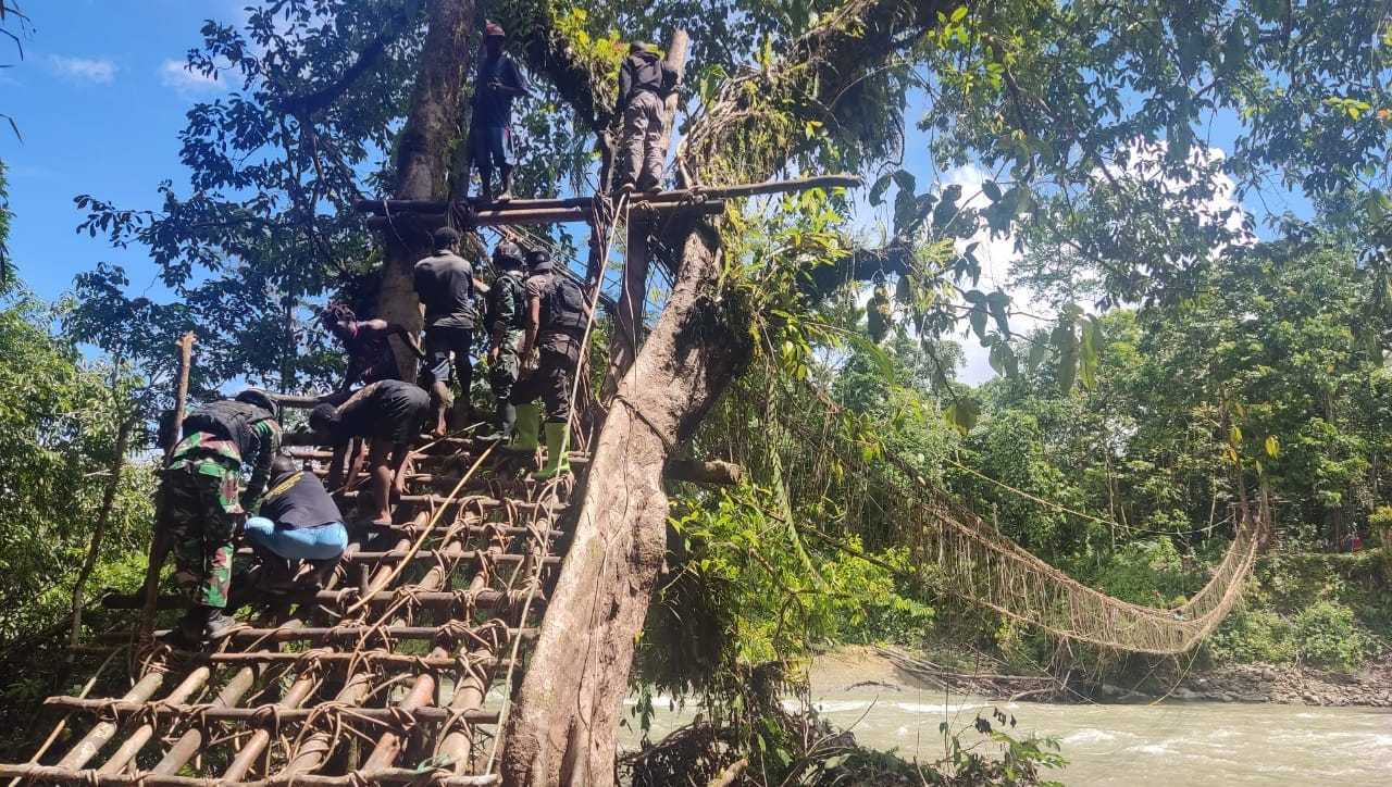 Anggota Satgas Yonif 143/TWEJ Perbaiki Jembatan