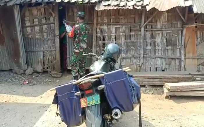 Dengan Sepeda Motor Penuh Muatan Beras, Babinsa TNI Terobos Medan Berat untuk Membantu Warga