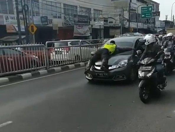 Periksa Pelanggar, Polisi Nemplok di Kap Mobil